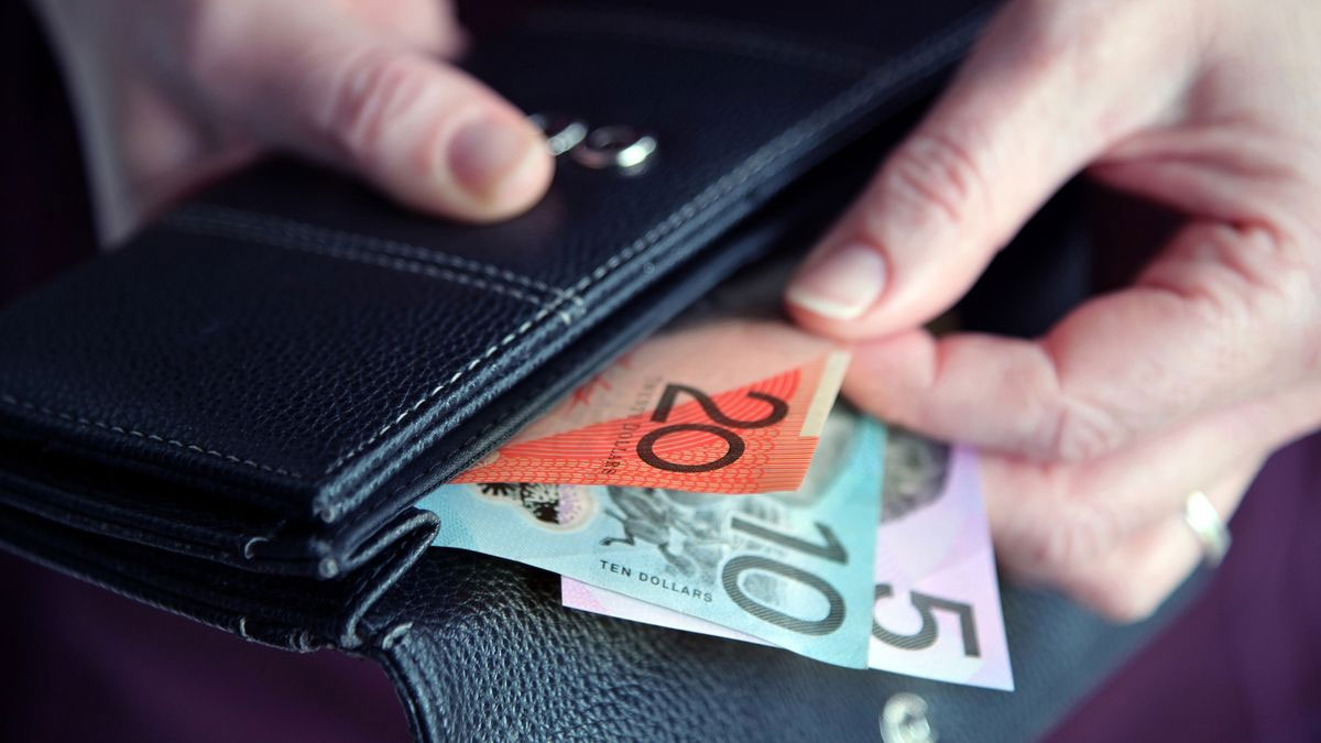 Adult woman female hand pulling out Australian money from a leather wallet. (Getty ImagesiStockphoto)