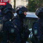 Heavily armed police surrounded a home nearby before eventually kicking the door down and arresting a 62-year-old man. (9News)