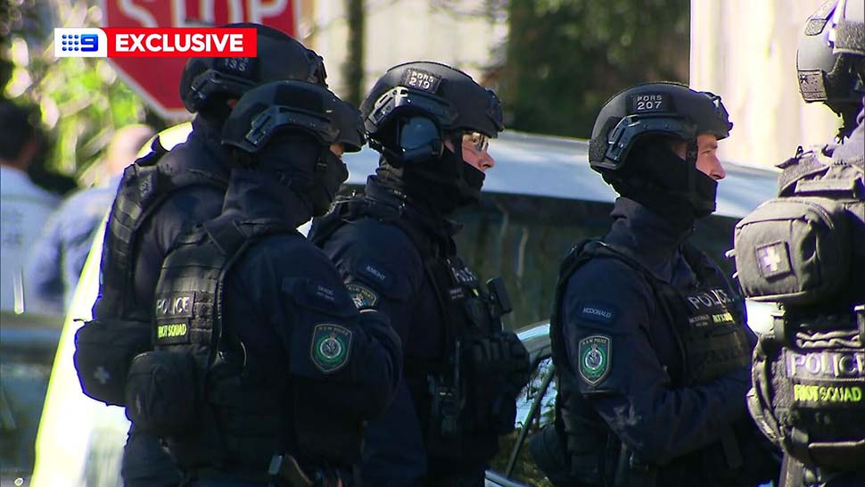 Heavily armed police surrounded a home nearby before eventually kicking the door down and arresting a 62-year-old man. (9News)