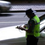 A parking inspector issues a ticket to a car parked on Macquarie Street in Sydney’s CBD. (SMH Wade Laube)