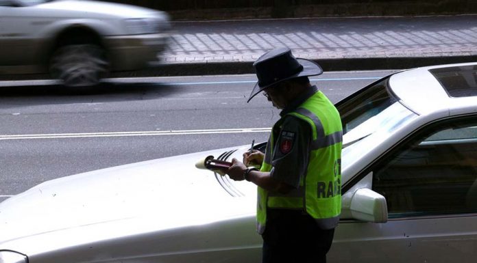 시드니의 주차 미터기, 사라질지도 A parking inspector issues a ticket to a car parked on Macquarie Street in Sydney's CBD. (SMH Wade Laube)