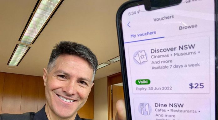 NSW 바우처 관리비용만 1,400만 달러 들여 Digital and Customer Service Minister Victor Dominello with the NSW Government's Service NSW app showing the Dine & Discover vouchers. Source LinkedIn
