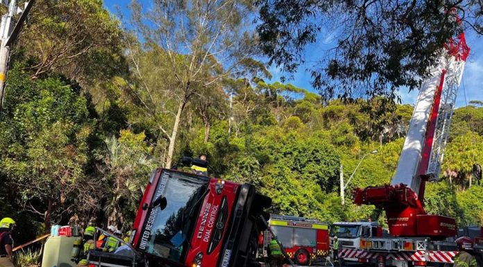 시드니 북부 해변에서 쓰레기 트럭 전복 사고 Police have launched an investigation after a tradie was flown to hospital after he spent almost three hours trapped underneath a garbage truck in Sydney’s northern beaches. Picture NSW Ambulance