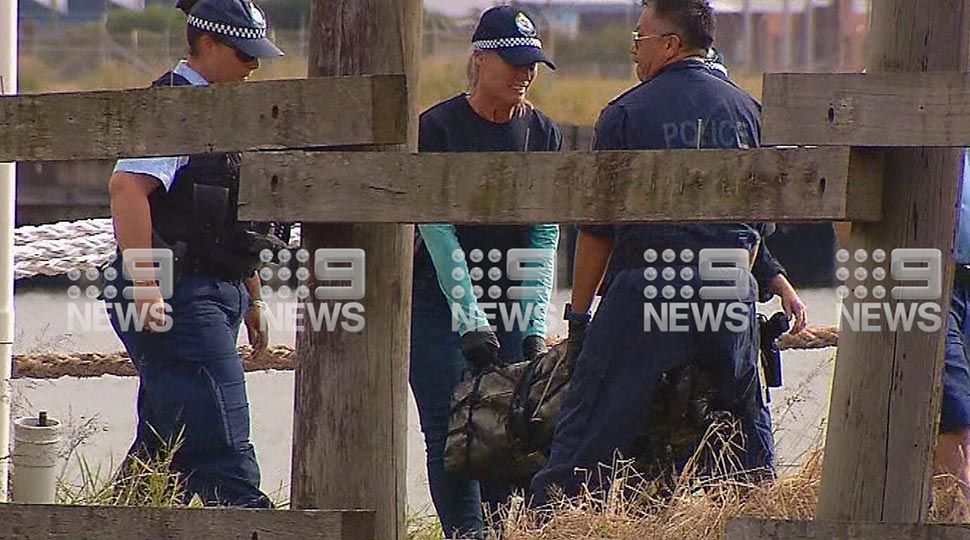 NSW Police carry a package containing white powder, believed to be cocaine, to shore. (9News)