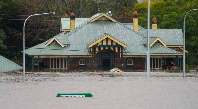 100건 이상의 홍수 신고, NSW 전체에 경고 A building is inundated with water on the far side of the Windsor Bridge at Windsor on the outskirts of Sydney. (AP)
