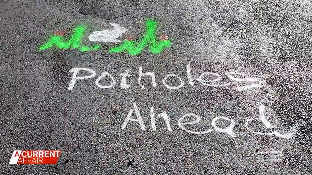 Passersby stop to thank the pothole lady. (A Current Affair)