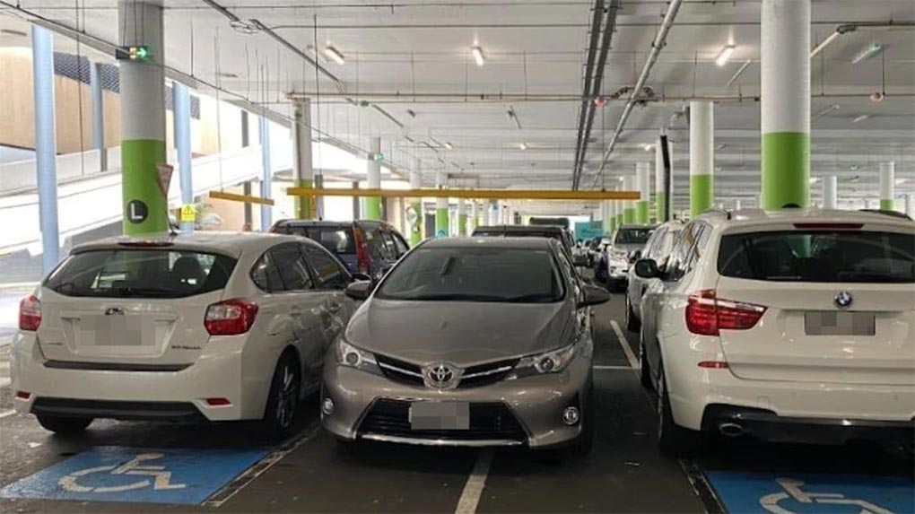 This driver was slammed online for parking between two cars parked in disabled bays in Westfield Eastgardens, Sydney. Picture Facebook