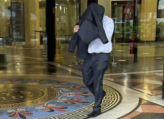 수갑 찬 원주민 십대 얼굴을 발로 찬 시드니 경찰 The former police officer placed a jacket over his head before leaving Sydney’s Downing Centre on Wednesday. Picture NCA NewsWire Adelaide Lang