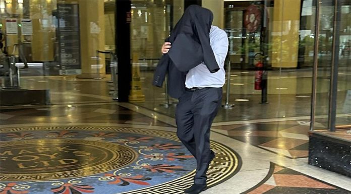 수갑 찬 원주민 십대 얼굴을 발로 찬 시드니 경찰 The former police officer placed a jacket over his head before leaving Sydney’s Downing Centre on Wednesday. Picture NCA NewsWire Adelaide Lang