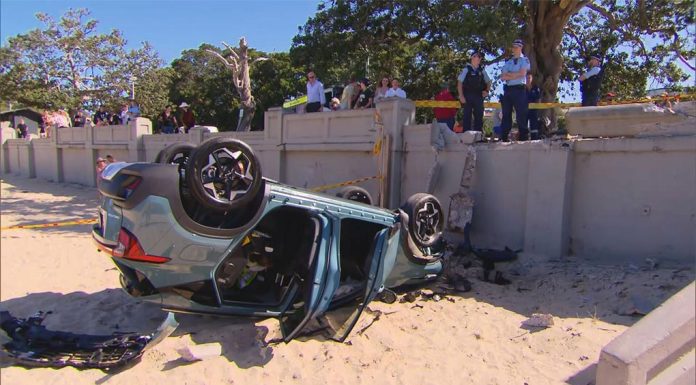 시드니 발모랄 해변 , 자동차 전복, 운전자는 무사 The car crashed through a concrete wall onto the busy beach. (9News)