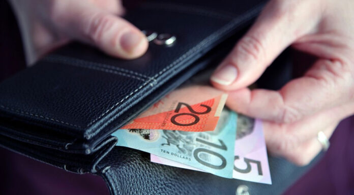 호주 젊은이들 생활비 경색으로 가장 큰 타격입어 Adult woman female hand pulling out Australian money from a leather wallet. (Getty ImagesiStockphoto)