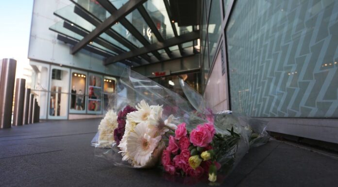 본다이 웨스트필드 칼부림 피해자의 파트너, 지역사회의 지원에 놀라다 Flowers laid outside the Westfield shopping centre at Bondi Junction after a stabbing spree left six dead. (Lisa Maree Williams)