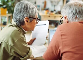 호주 연금 기금 협회(ASFA) 호주인들에게 고통을 안긴 시스템적 오류에 사과 Rear view of casually clothed senior couple going over paperwork at home (Getty)