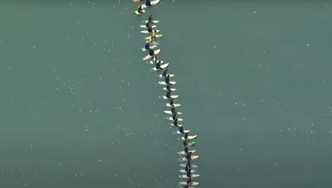 They held hands or locked arms during the paddle out. Picture Channel 7