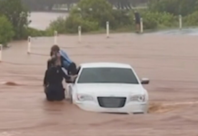 퀸즐랜드 번다버그 인근 홍수 차량서 어린이 구조 Footage appears to show a child being pulled from a car by police on a flooded causeway at Bargara. (Facebook)_9NEWS