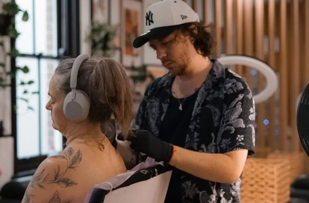Cal Baker, pictured here with a client, got his first car from a mate in exchange for a free tattoo session. Cal Baker_9news