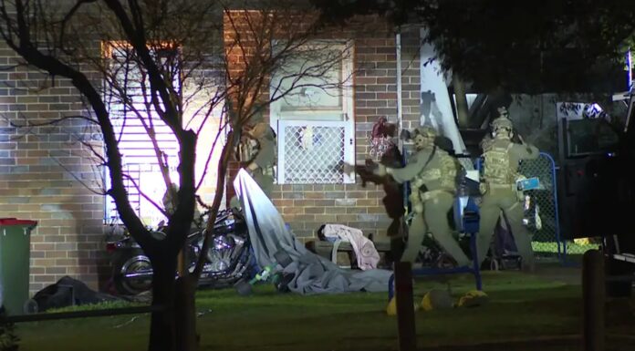 시드니 칼링포드 총격 사건, 경찰 압수수색으로 남성 기소 Heavily armed police swarmed the building with helicopters circling above. Supplied._9NEWS