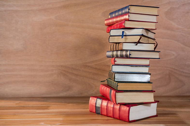 Stack of various books on a wooden table freepik